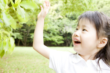 Obraz premium 木の葉を掴もうとする女の子