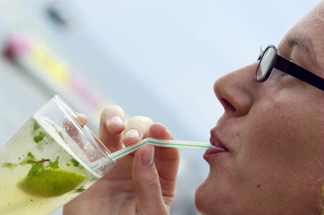 Woman enjoying a cocktail ( Mojito ) at the beach