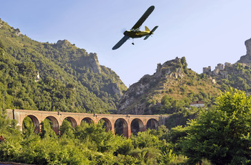 Airplane flying over a bridge on Mount Bulgheria, Salerno, Italy