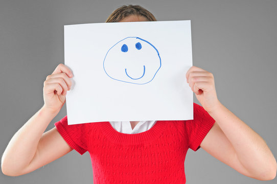 Girl hiding behind happy face