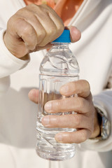 ペットボトルを持つ男性の手元