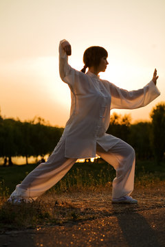 woman in white suit make's taiji chuan exercise - 7