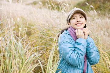 ススキ野原に立つ女性