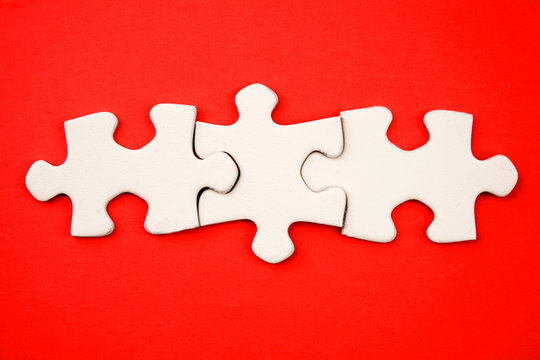 Three Jigsaw Puzzle Pieces On Red