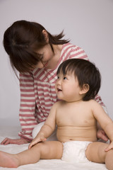 座って笑い合っている母親と赤ちゃん