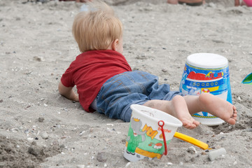 enfant à la plage avec ses seaux
