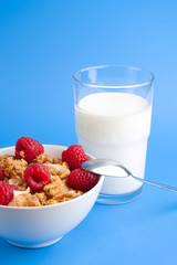 cornflakes with raspberries & milk on blue