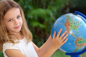 Fillette avec un globe terrestre.