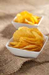 potato crisps in white bowls on hessian backdrop