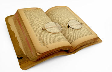 Antique book with gold-rimmed spectacles