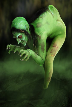 Green looking witch like creature in swamp