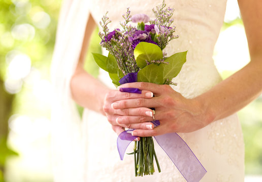 A bride holds a bouquet of flowers.