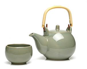 Ceramic teapot and a tea cup over white background
