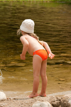 Petite fille pench&eacute;e sur l'eau