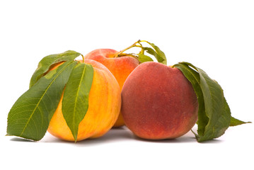 Peach fruits with green leafs isolated on white background