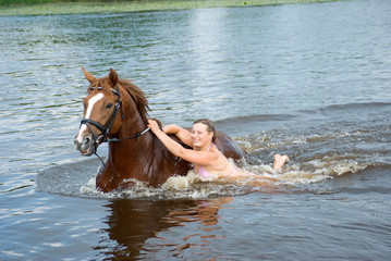 woman swimming winth  stallion in river