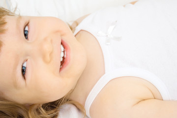 Obraz na płótnie Canvas Smiling girl in a bed