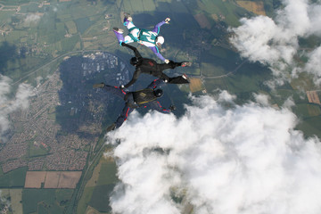 Three skydivers doing formations