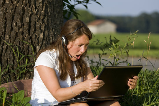 frau blickt sprachlos auf laptop