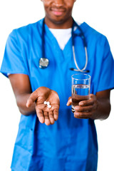 Close-up of an Young doctor holding pills and glass of water
