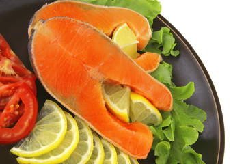 two salmon steak on dark dish