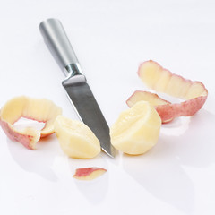 potatoes with knife against the white background