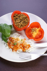 Red mince filled paprika with basil leaf, rice and sauce