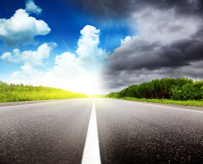 road black clouds and sun