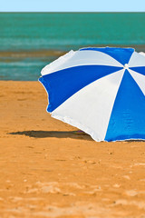 Pleasant sitting under a colorful umbrella on perfect tropical b