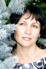 Portrait attractive brunette on a background a blue fir-tree