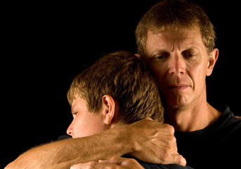 Father cries as he hugs son
