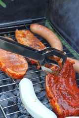 Grillfleisch wird gewendet