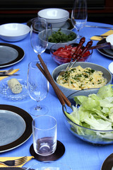Gedeckter Tisch mit Salaten zum Grillen