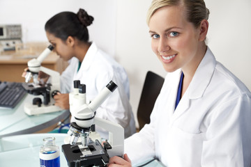 Female Scientific Research Team Using Microscopes in Laboratory