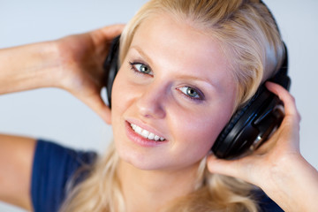 Naklejka premium Blonde woman listening music with headphones
