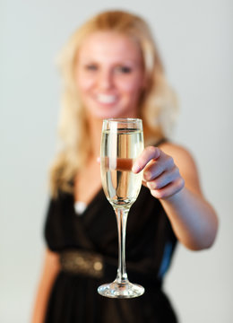 Beautiful woman holding a glass of champagne focus on champagne