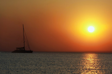 Fototapeta na wymiar ship silhouette on sunset sea background