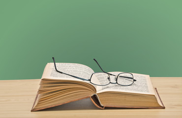 Eyeglasses on open book