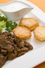 Grilled meat with baked potatoes and vegetable salad