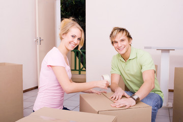 Fototapeta na wymiar couple packing boxes to move house