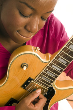 young hispanic black woman playing electric guitar