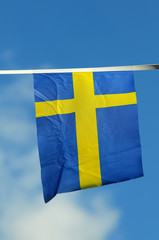 Small Swedish flag against blue sky