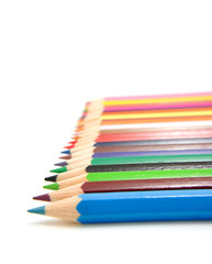 colored pencils in a row over white background