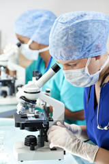 Female Scientific Research Team Using Microscopes in Laboratory