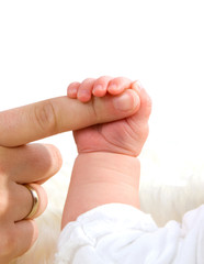 Mother is holding baby's hand on white background