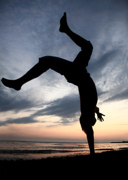 Acrobatic boy on beach