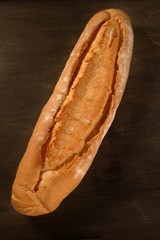 Bread loaf over dark brown wood