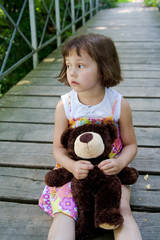 5 years old girl on the bridge with teddy bear