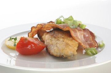 carp with bacon and tomato on a plate