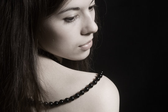 Portrait of the young brunette on a black background.